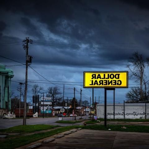 A Dollar General sign is illuminated against a dark sky